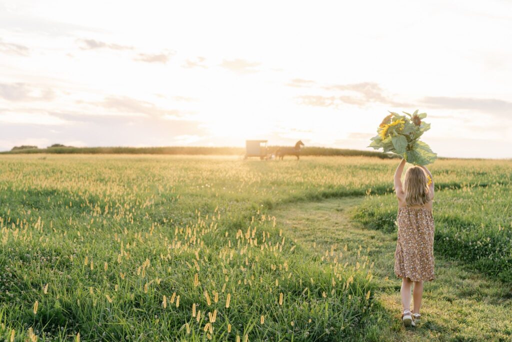 The Best Kids' Activities in Lancaster, PA 8 Girl carries sunflowers through field at our Lancaster Bed and Breakfast, one of the best farm stays in PA.